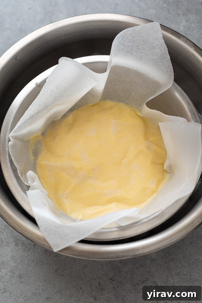 Pastry cream covered with buttered parchment paper, preventing a skin from forming during chilling.
