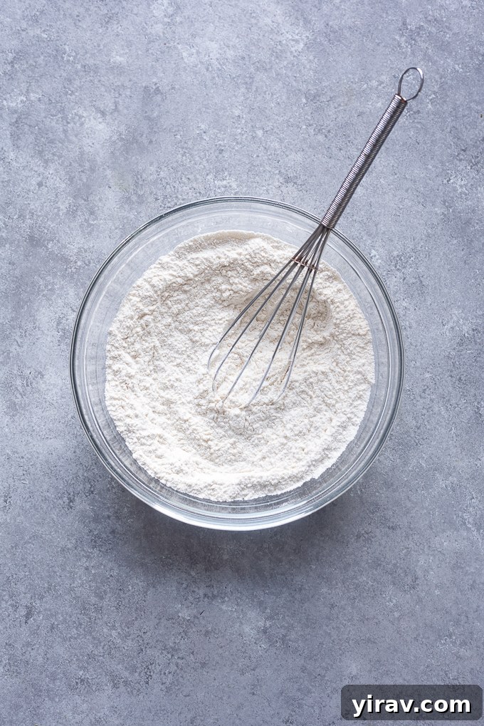 Whisked dry ingredients (flour, baking powder, salt) in a bowl for vanilla cupcakes.