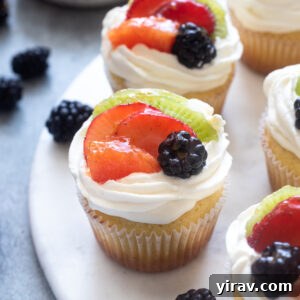 Fruit tart vanilla cupcakes on a serving board.