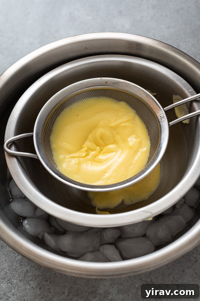 Pastry cream being strained through a fine-mesh sieve over an ice bath, ensuring a silky-smooth consistency.