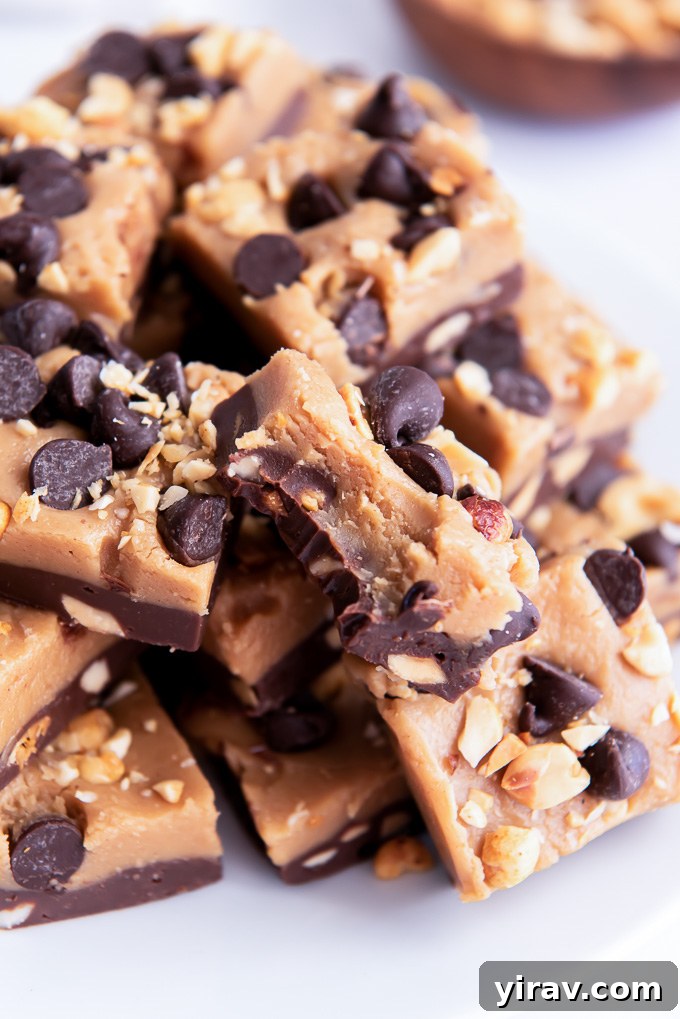 A square of chocolate peanut butter fudge with a bite taken out, showing the distinct layers and creamy texture within.