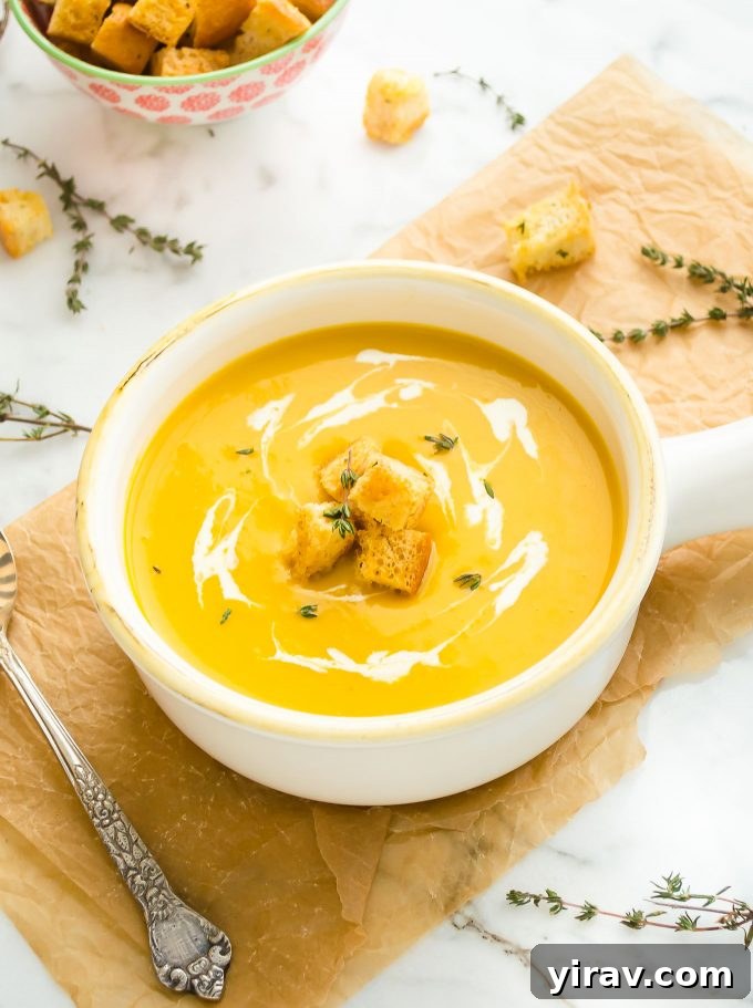 Velvety smooth butternut squash potato leek soup in a white bowl, garnished with crunchy croutons, perfect for a cozy fall evening.