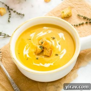 Butternut squash potato leek soup in a white bowl with crunchy croutons on top, presented beautifully.
