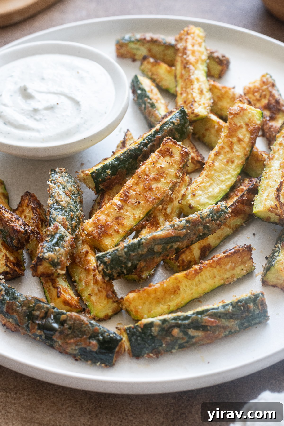31 Tailgating Snacks That Steal the Show 12 Golden brown air fryer zucchini fries generously coated in parmesan cheese, served with a side of creamy Greek yogurt ranch dip.