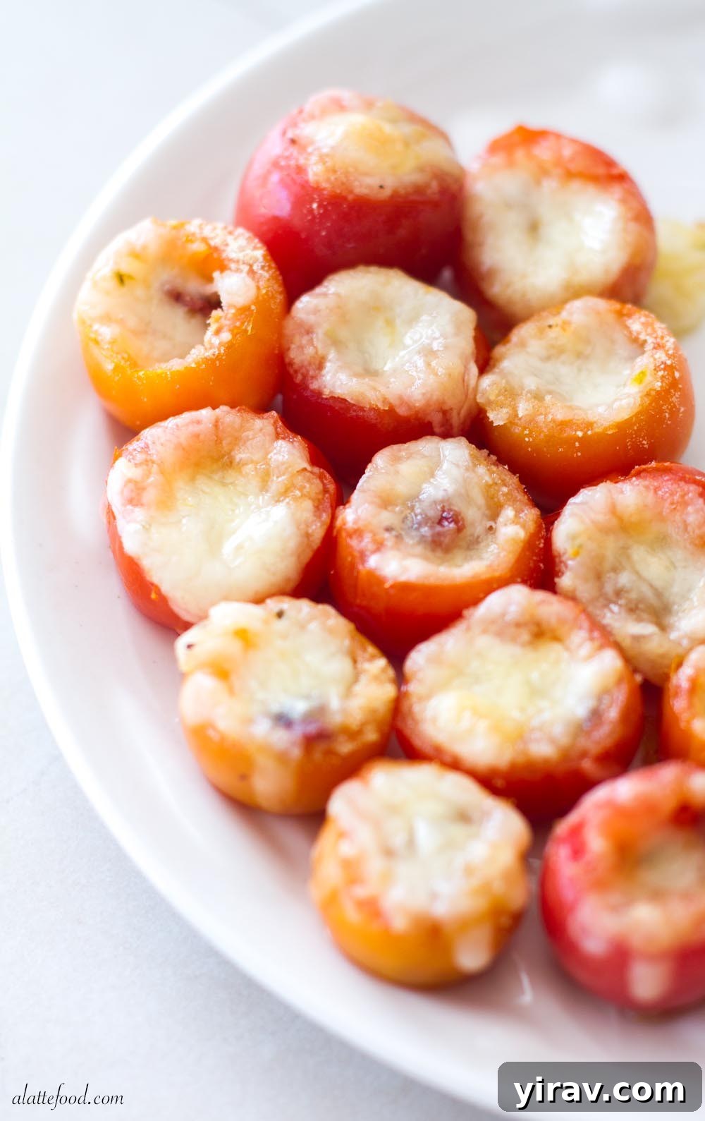 31 Tailgating Snacks That Steal the Show 17 Elegantly arranged stuffed cherry tomatoes on a crisp white plate, ready to be served.