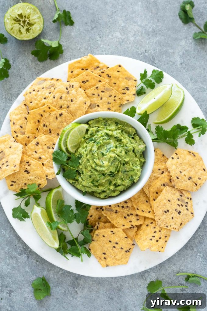 31 Tailgating Snacks That Steal the Show 18 Fresh homemade guacamole beautifully arranged on a platter with tortilla chips and lime wedges.