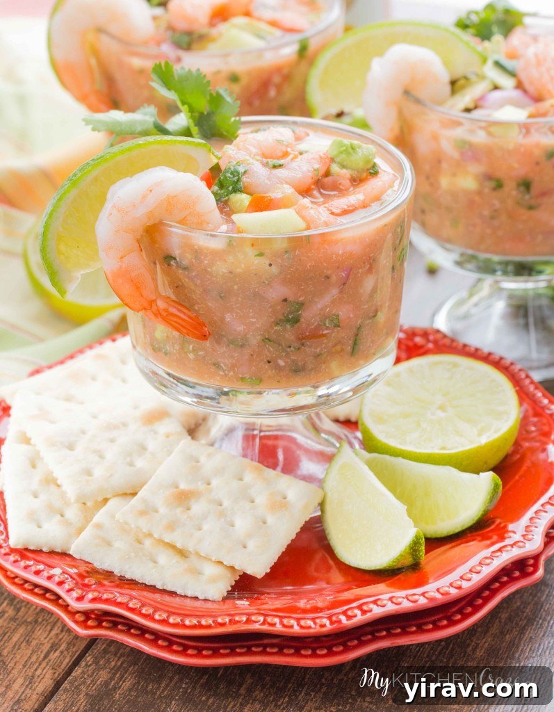31 Tailgating Snacks That Steal the Show 19 A vibrant Mexican shrimp cocktail served in a glass, garnished with fresh lime and cilantro.