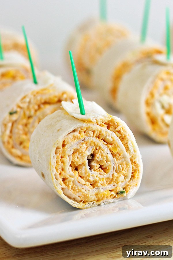 31 Tailgating Snacks That Steal the Show 26 Neatly arranged buffalo chicken tortilla pinwheels on a pristine white plate.