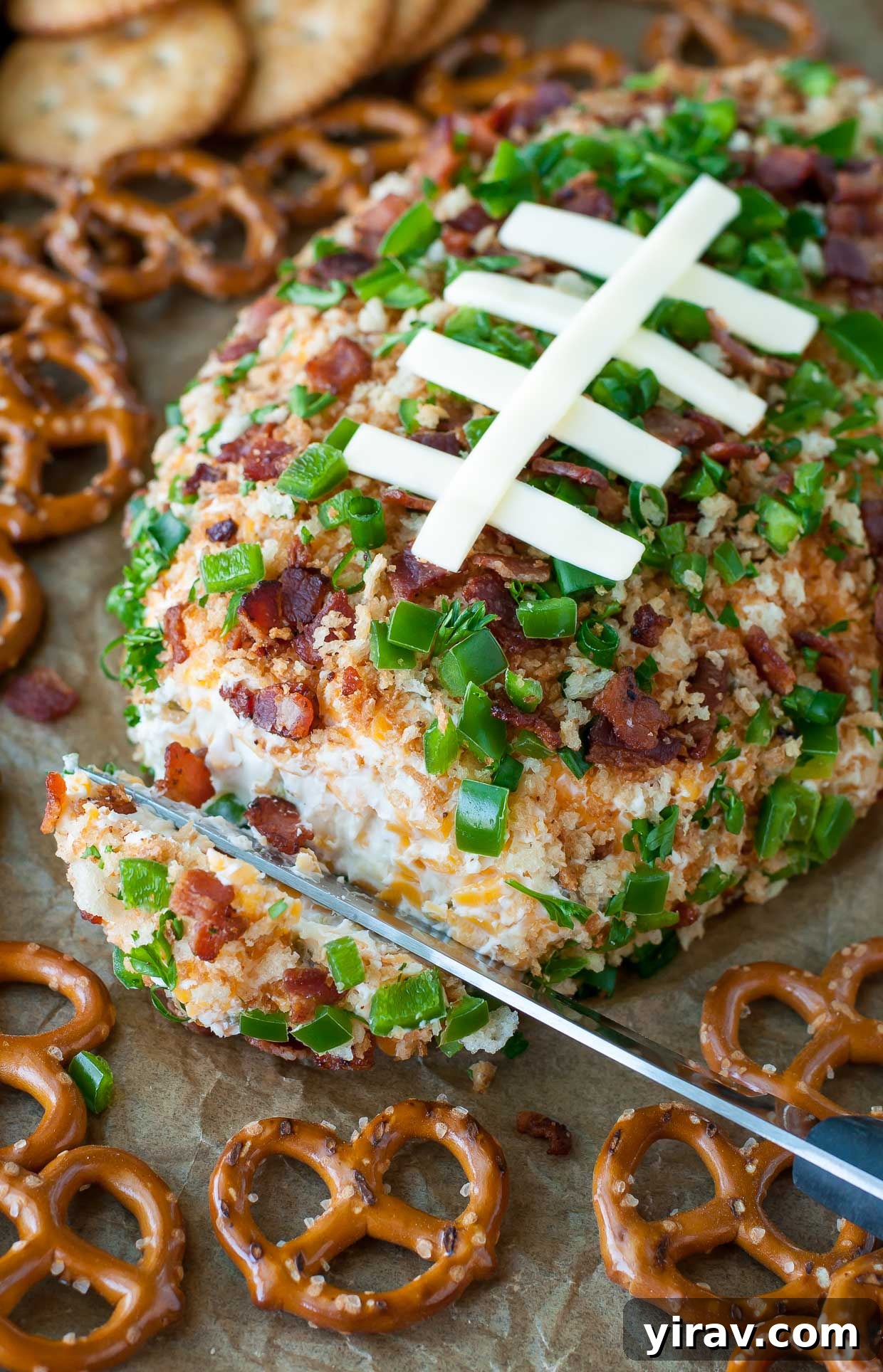 31 Tailgating Snacks That Steal the Show 4 A festive jalapeño popper football cheese ball, perfect for a game day spread.