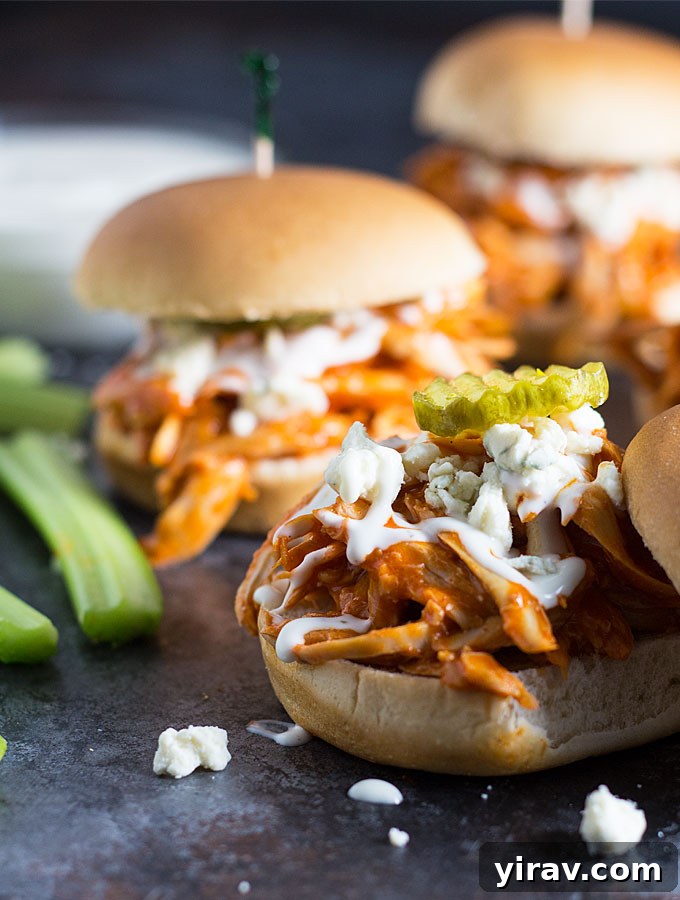 31 Tailgating Snacks That Steal the Show 6 Delicious buffalo chicken sliders adorned with blue cheese crumbles and a pickle slice.