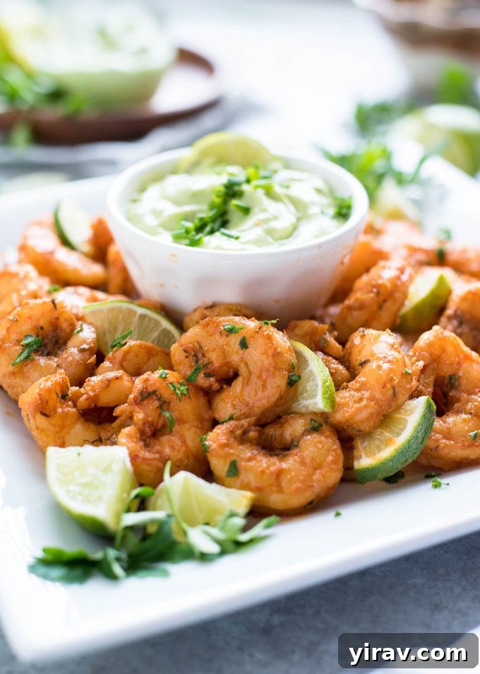 31 Tailgating Snacks That Steal the Show 7 Appetizer of blackened shrimp served alongside a vibrant green avocado ranch dressing.