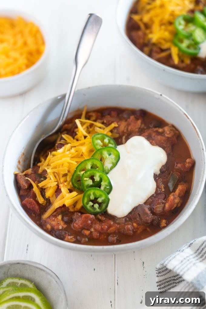 A steaming bowl of Slow Cooker Turkey Chili, garnished with fresh cilantro and a dollop of sour cream, ready to be enjoyed on a chilly evening.