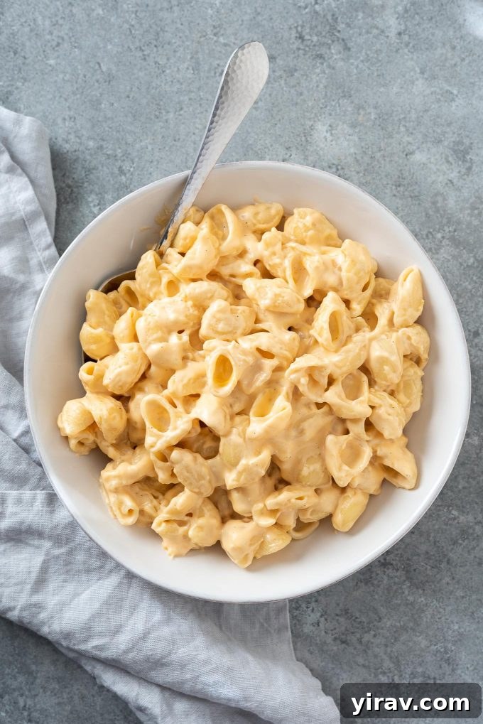 A generous serving of creamy Stove Top Mac and Cheese in a white bowl, ready to be enjoyed.
