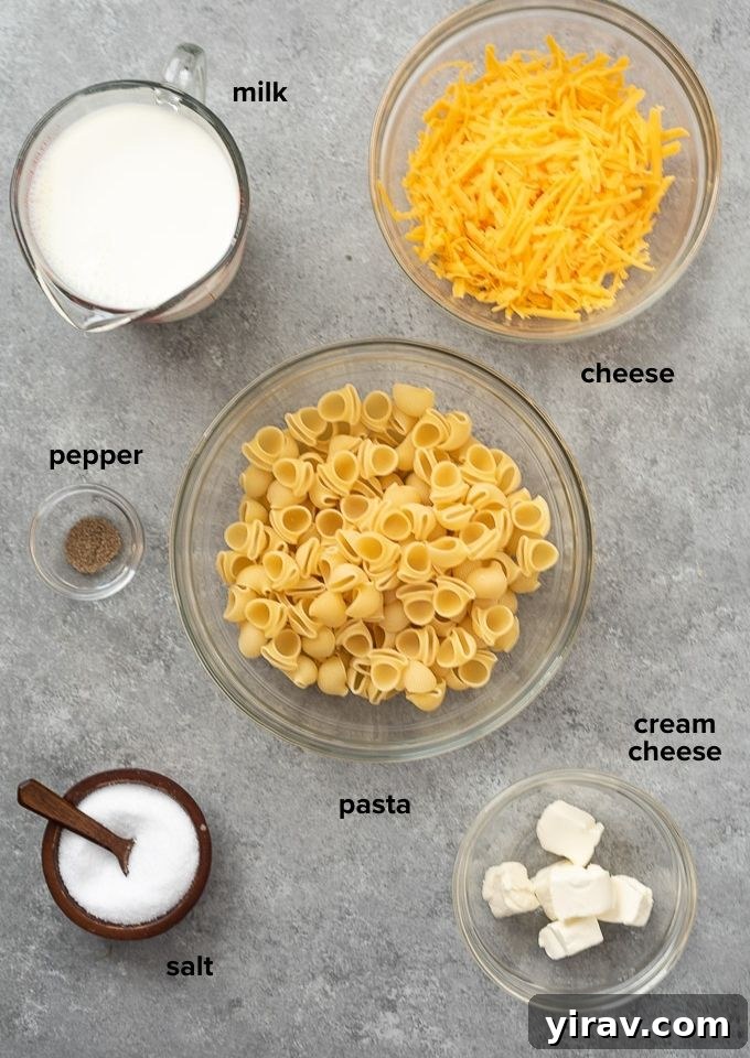 A flat lay of the essential ingredients for stove top mac and cheese: pasta, milk, water, cheddar cheese, and cream cheese.