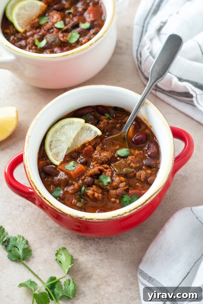 Chorizo chili in a bowl with a spoon buried inside.