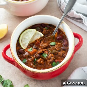 Chorizo chili in a bowl with a spoon buried inside.