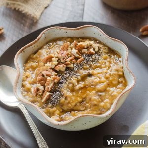 A bowl of pumpkin steel cut oats, garnished with chia seeds and pecans on top, ready to be served.