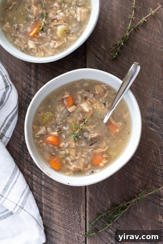 Hearty Slow Cooker Turkey Wild Rice Soup in a bowl with a spoon, perfect for using leftover turkey.