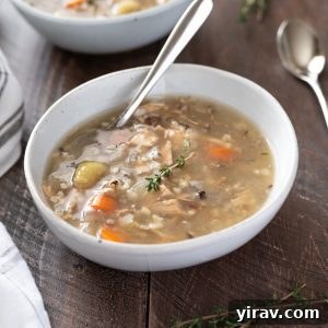 Hearty Slow Cooker Turkey Wild Rice Soup in a bowl with a spoon, ready to be served.