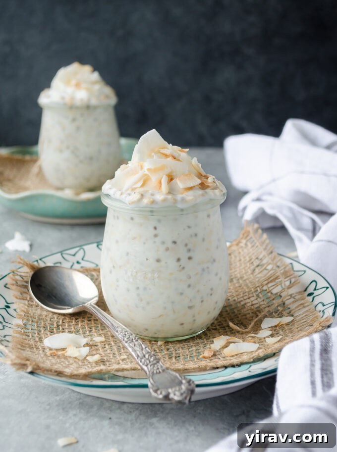 Two jars of coconut overnight oats, garnished with toasted coconut flakes, ready to be enjoyed as a healthy meal prep breakfast.