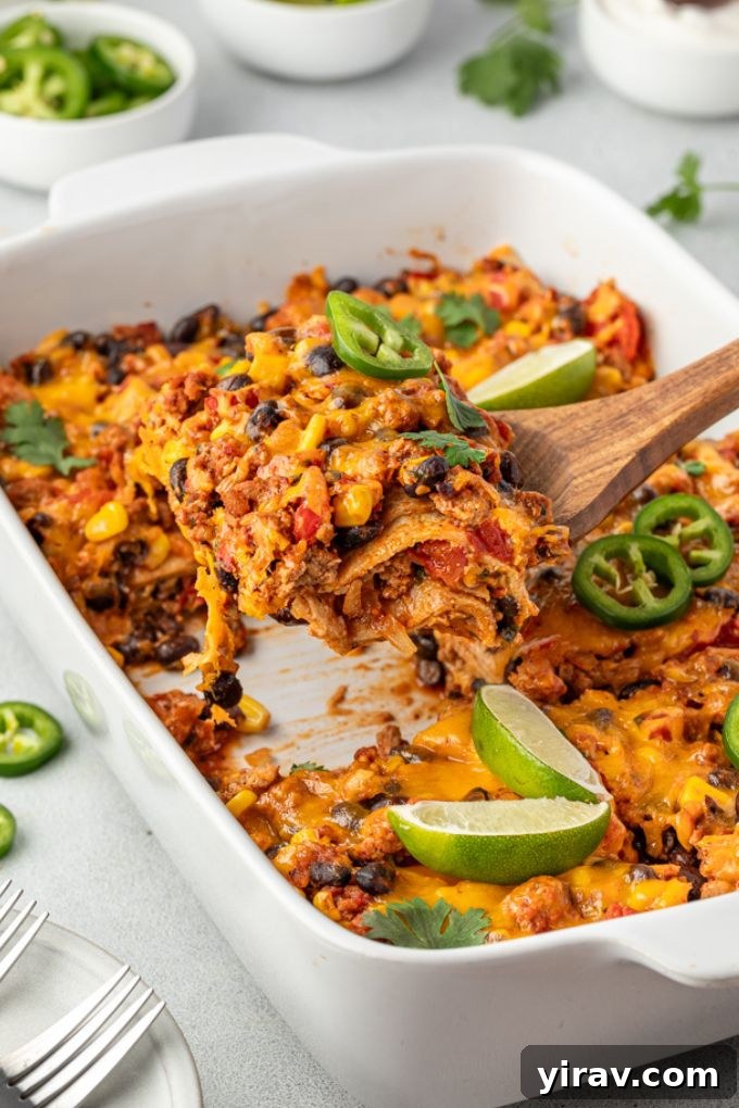 Serving of Mexican tortilla casserole being lifted out of baking dish