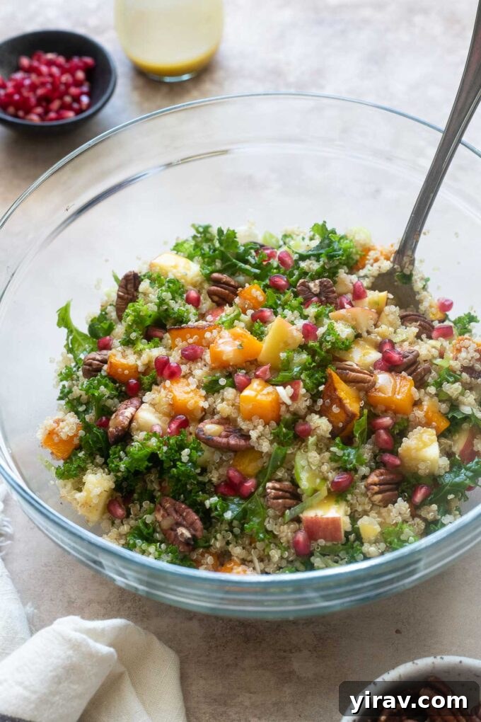 Butternut squash and quinoa salad in a large glass mixing bowl, perfectly tossed.