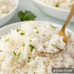 Coconut rice in a bowl with a fork digging in