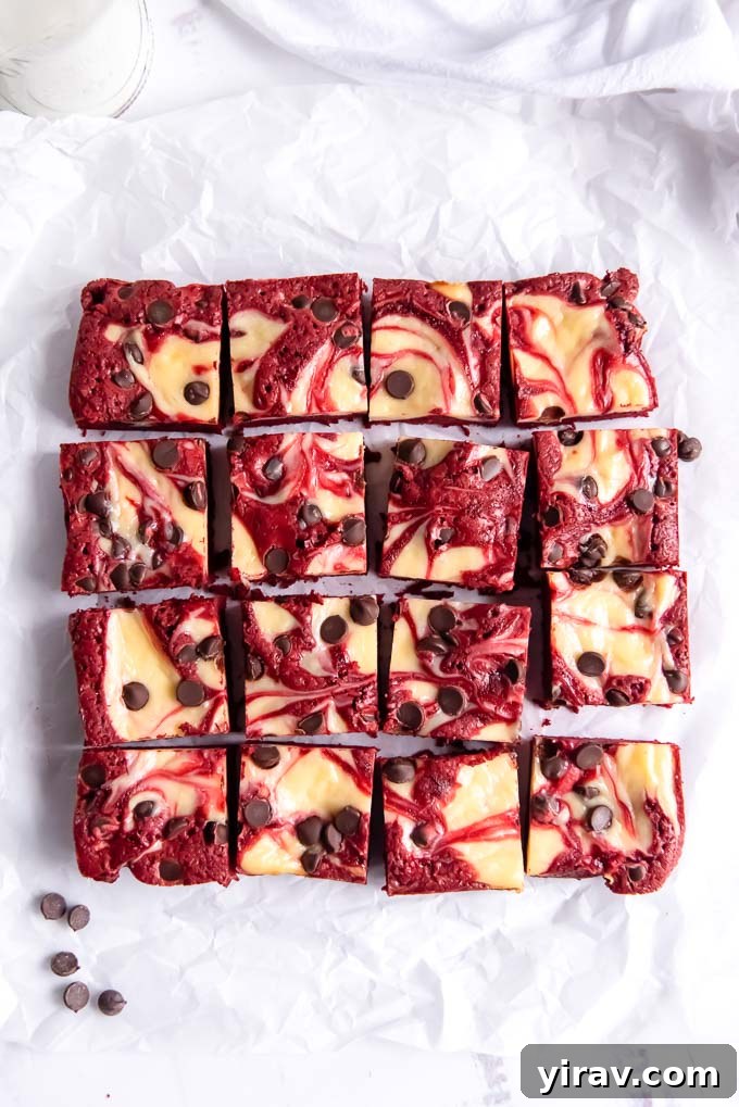 Velvet Dream Brownies 3 Freshly baked Red Velvet Brownies, cut into perfect squares, showcasing their vibrant red color and white cheesecake swirl.