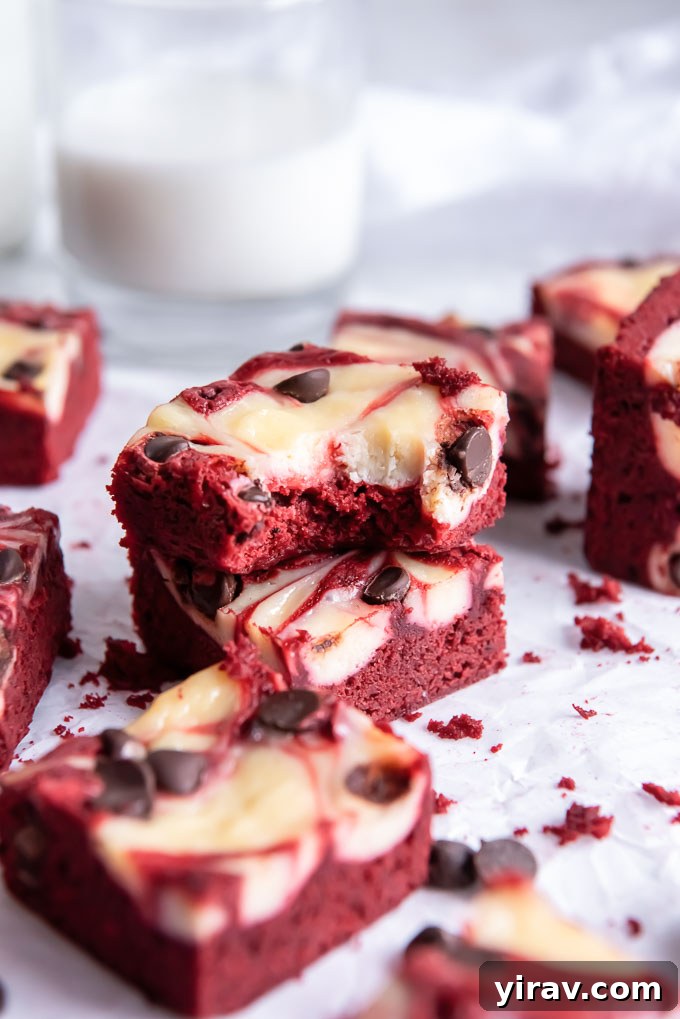 Velvet Dream Brownies 7 A close-up of a delightful Red Velvet Brownie with a small bite taken out, revealing its moist interior and the beautiful cream cheese swirl.