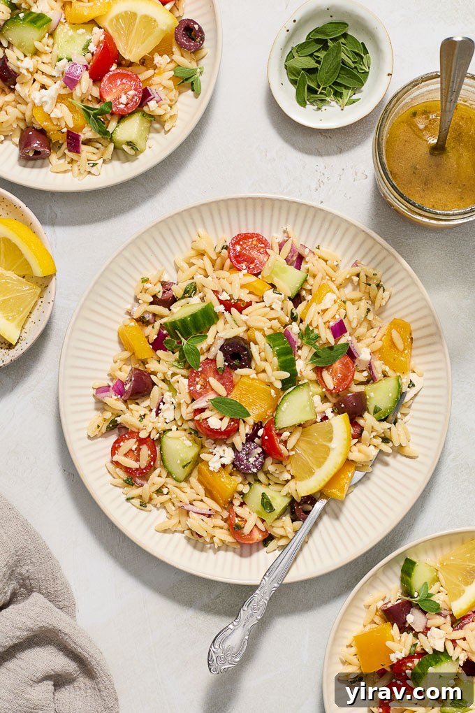 Greek pasta salad with orzo on serving plates.