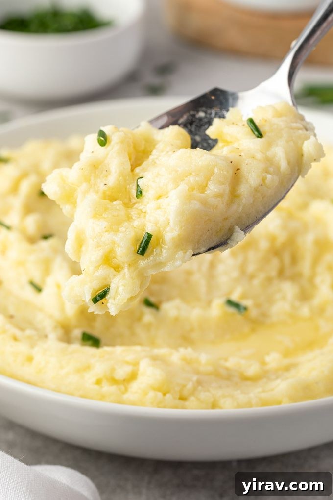 Sumptuous Yukon Gold Mashed Potatoes 7 A spoonful of creamy Yukon Gold mashed potatoes, showcasing its fluffy texture and inviting yellow hue.