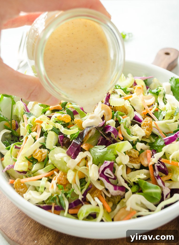 Golden Curry Coleslaw 4 Curried coleslaw dressing pouring over bowl of coleslaw