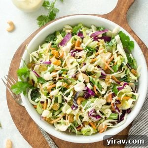 Bowl of curry coleslaw on a wooden cutting board