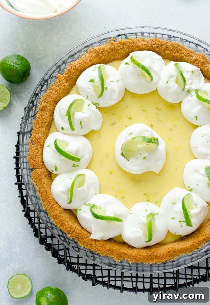 Key Lime Perfection 2 Key lime pie with whipped cream and lime slices, showcasing its creamy texture and fresh garnish