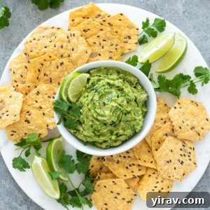 Homemade guacamole on platter with chips and lime