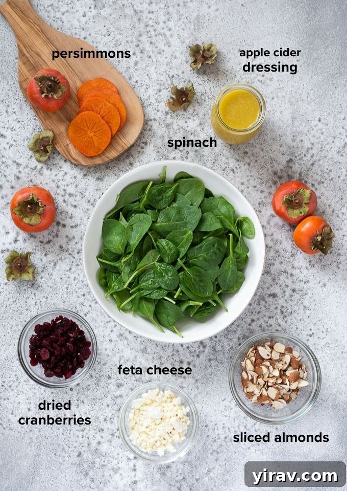 Golden Harvest Salad 4 A close-up shot of raw persimmon salad ingredients laid out, including fresh spinach, sliced Fuyu persimmons, dried cranberries, crumbled feta cheese, and sliced almonds.