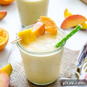 Peach mango smoothie in a jar with a straw
