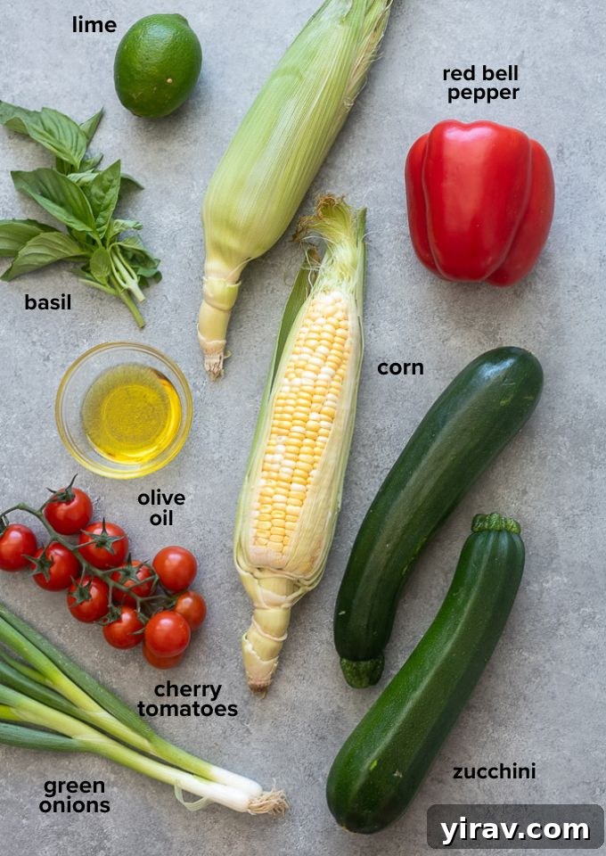 A flat lay of fresh ingredients for corn and zucchini salad, including olive oil, limes, green onions, cherry tomatoes, basil, corn, zucchini, and red bell pepper.