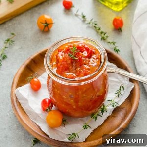 Cherry tomato jam in jar with thyme on top, a delicious homemade condiment.