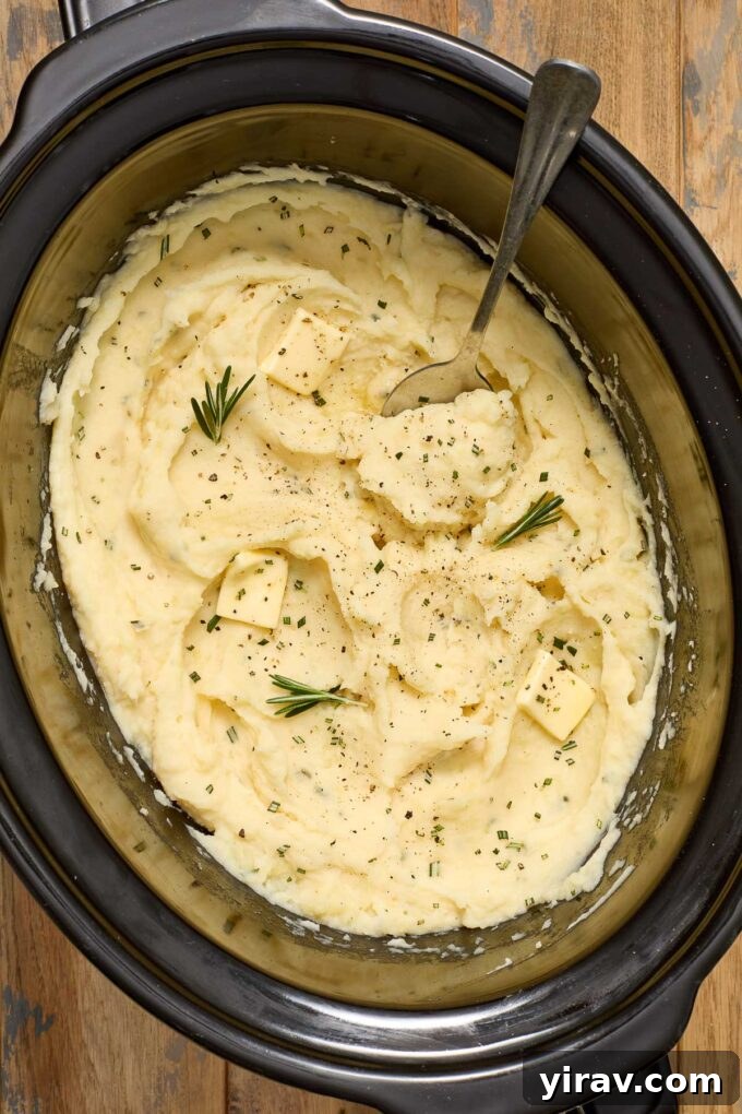 Creamy buttermilk mashed potatoes simmering in a crock pot, ready to be mashed.