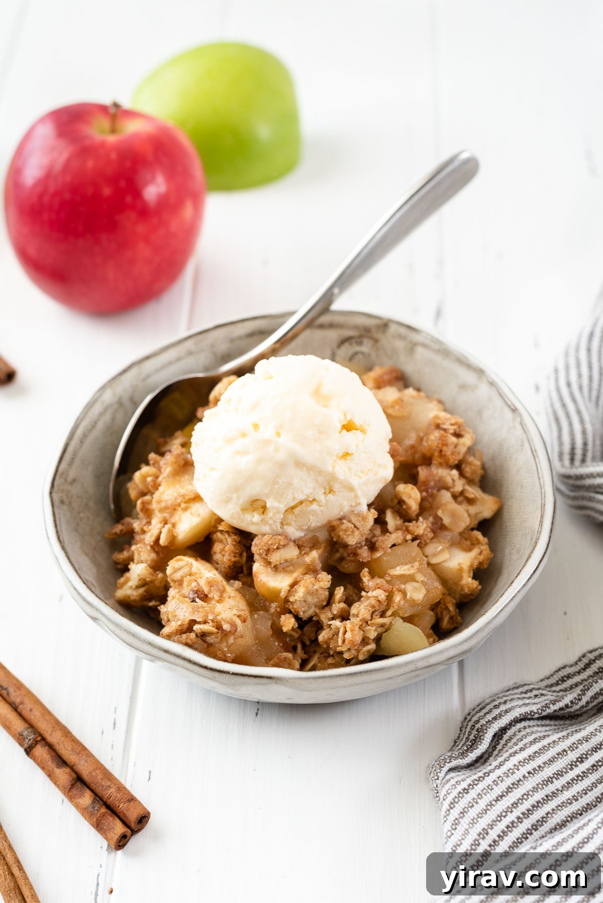 Effortless Apple Crisp 2 A beautiful bowl of warm apple crisp topped with a generous scoop of vanilla ice cream, ready to be enjoyed.