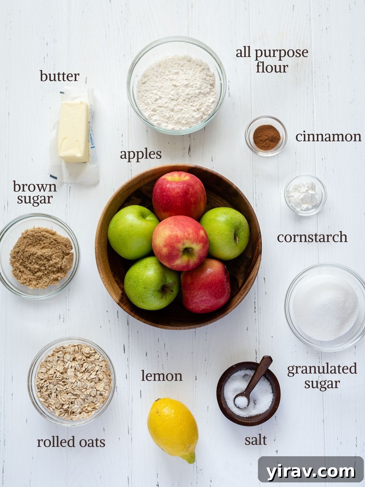 Effortless Apple Crisp 3 A vibrant flat lay showcasing all the fresh ingredients for homemade apple crisp: apples, butter, rolled oats, flour, sugars, and cinnamon.