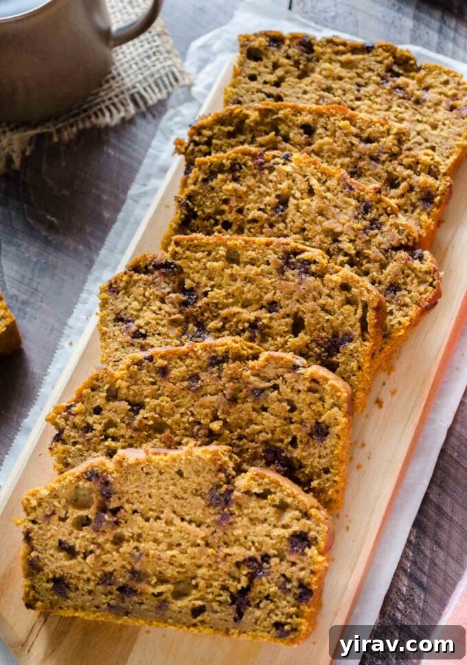 Spiced Pumpkin Chocolate Chip Bread 2 Sliced Whole Wheat Chocolate Chip Pumpkin Bread on a wooden cutting board, showcasing its moist texture and chocolate chips.