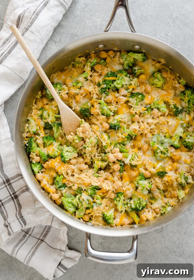 Easy One Pan Chickpea Broccoli Rice Bake 2 Golden cheesy chickpea broccoli rice casserole simmering in a rustic skillet, ready to be served.