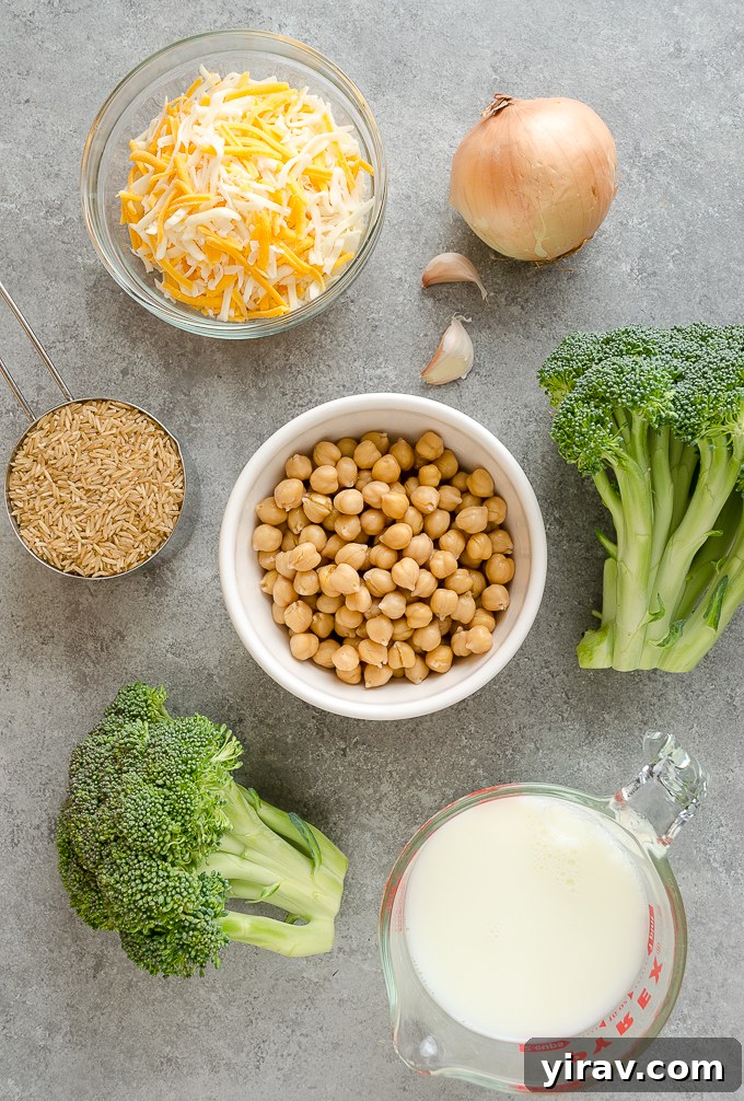 Easy One Pan Chickpea Broccoli Rice Bake 4 Fresh ingredients for vegetarian broccoli rice casserole including chickpeas, broccoli, brown rice, milk, broth, onion, and garlic on a white counter.