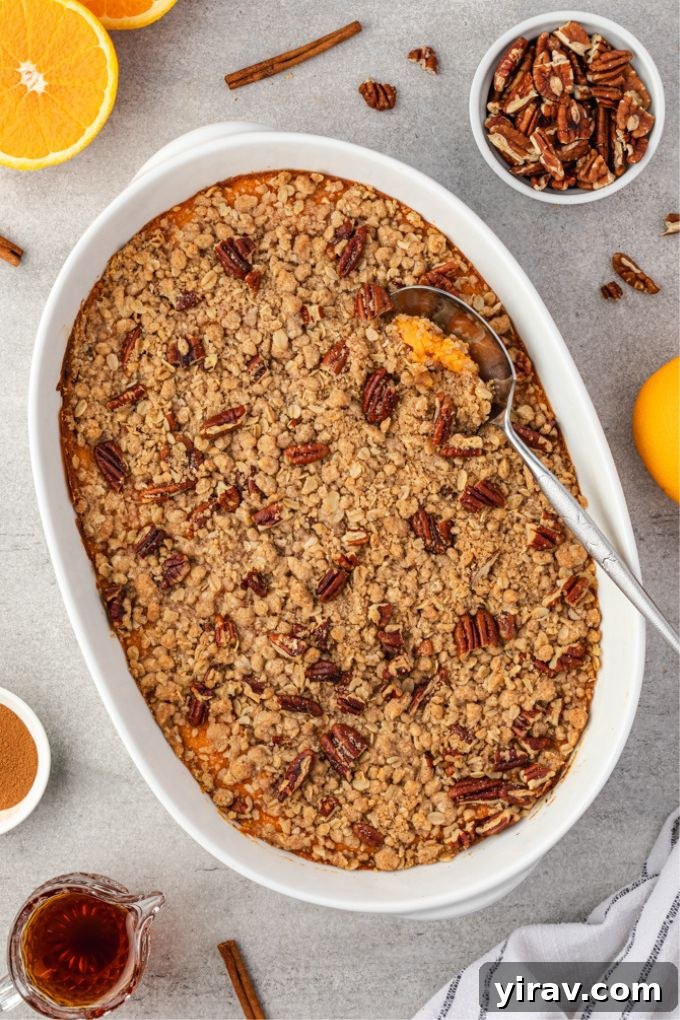 Sweet potato casserole in baking dish with a serving spoon, ready to be enjoyed
