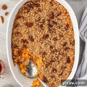 Spoon digging into sweet potato casserole with streusel topping