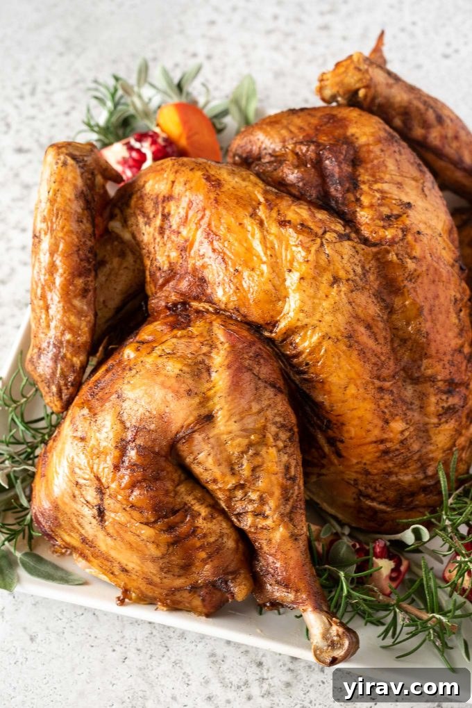Spatchcock turkey on serving plate with herbs and pomegranate