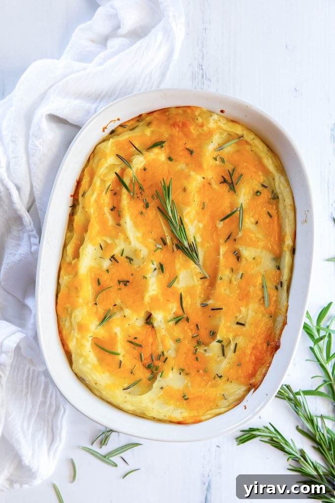 Twice baked mashed potatoes in a baking dish with rosemary on top