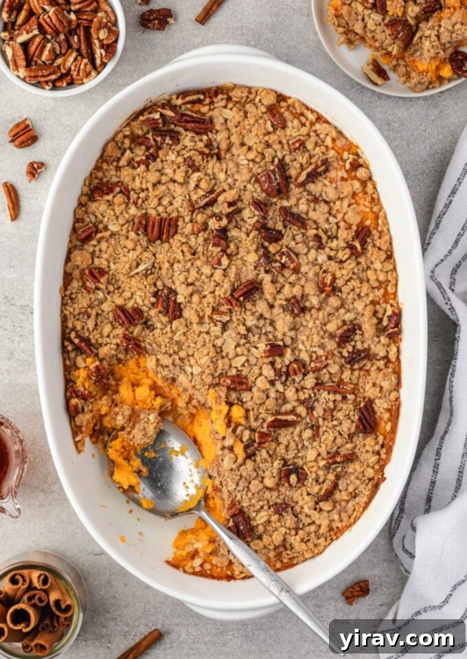 Spoon digging into sweet potato casserole with streusel topping